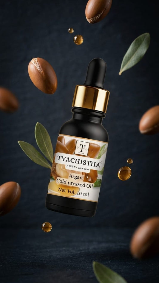 A black glass dropper bottle of Tvachistha Cold Pressed Argan Oil showing its rich, unrefined golden texture.